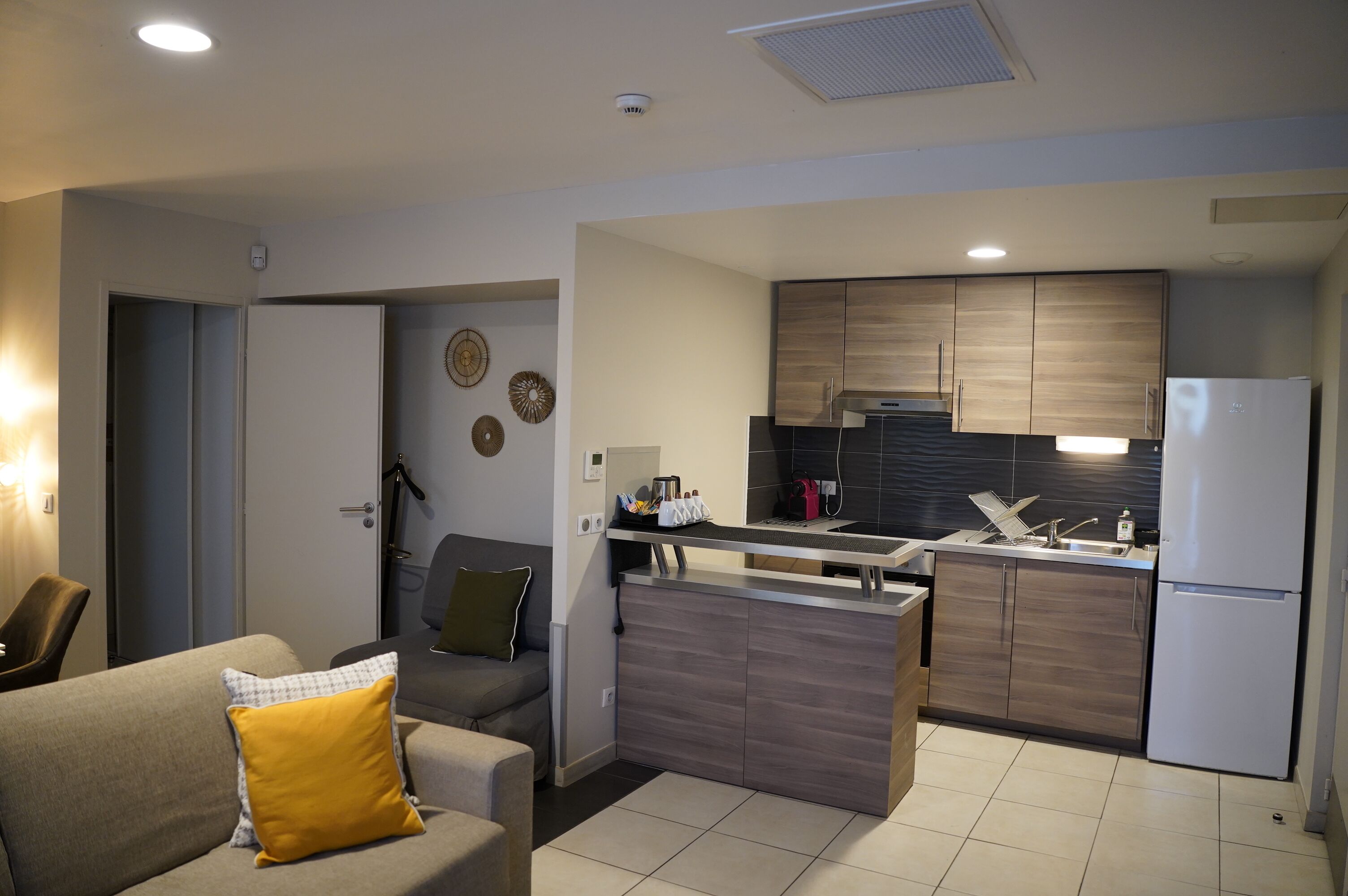 A modern kitchen with a built-in island, a dining area with a sofa, and a living room with a couch.