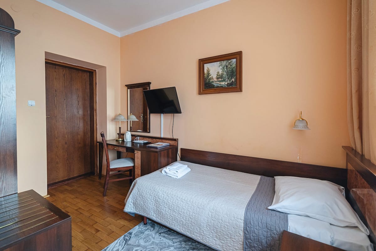 Une chambre d’hôtel équipée d’un lit, d’un bureau, d’une chaise et d’un téléviseur.