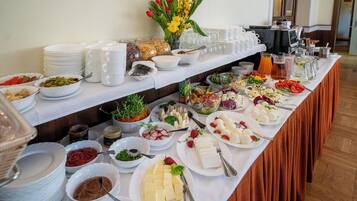Una mesa de buffet con diversos alimentos y utensilios.