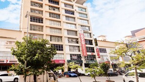 Un hôtel à plusieurs étages, doté d’une façade moderne, de nombreux balcons et d’une enseigne « Hôtel » bien visible.