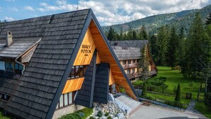Un bâtiment moderne doté d’un toit en pente, d’une façade en bois et d’une enseigne indiquant « BIALY POTOK ».