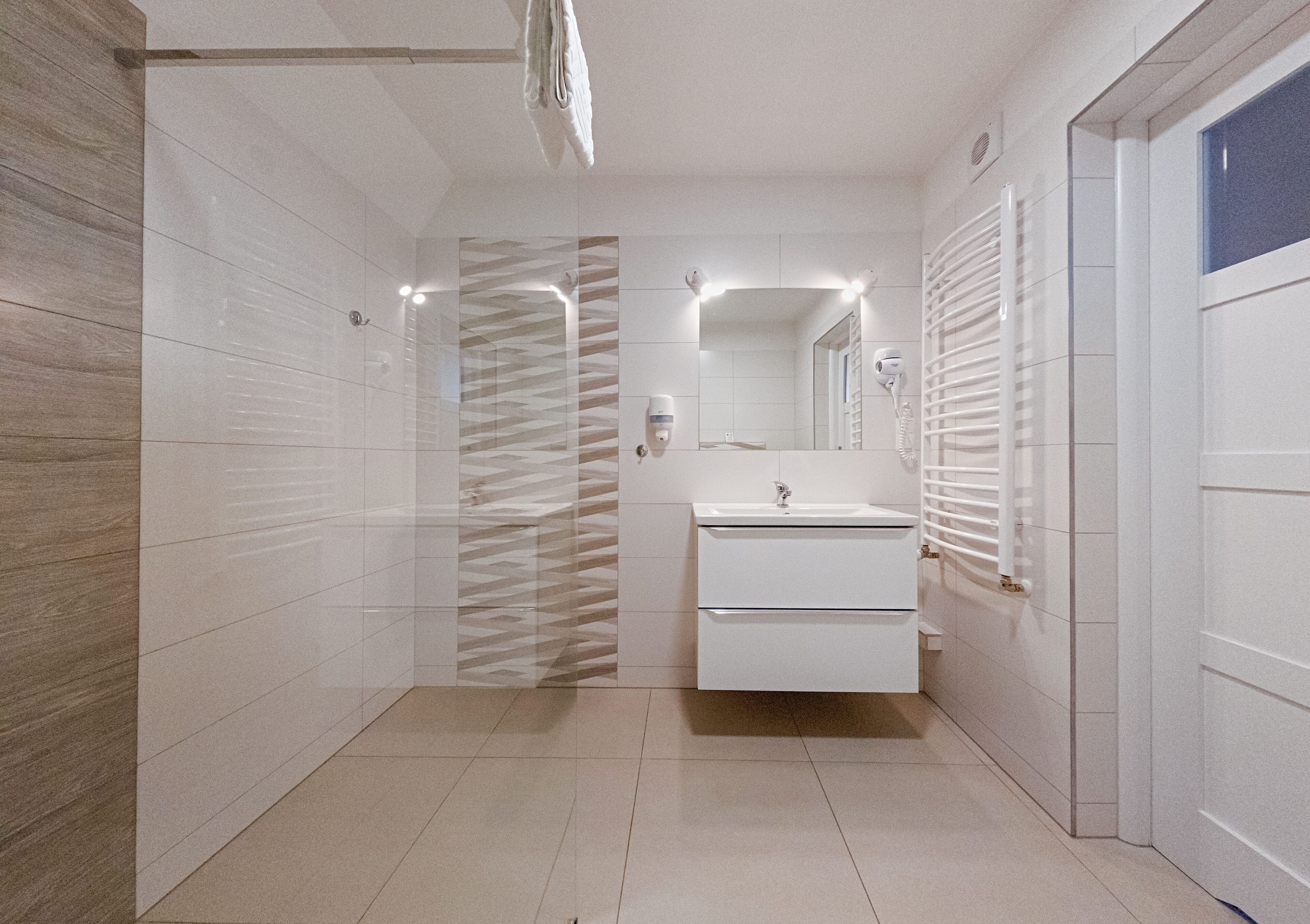 Un baño moderno con ducha, lavabo y espejo.