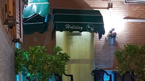 Un espacio exterior cubierto con plantas en macetas, una mesa y sillas.