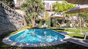 Alberca al aire libre y camastros