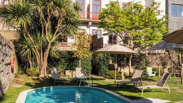 Alberca al aire libre y camastros