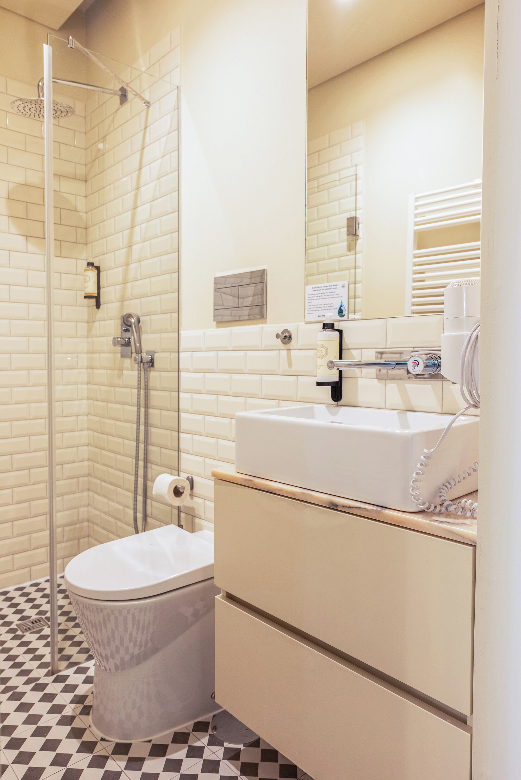 Un bagno con doccia, toilette, lavandino e specchio.