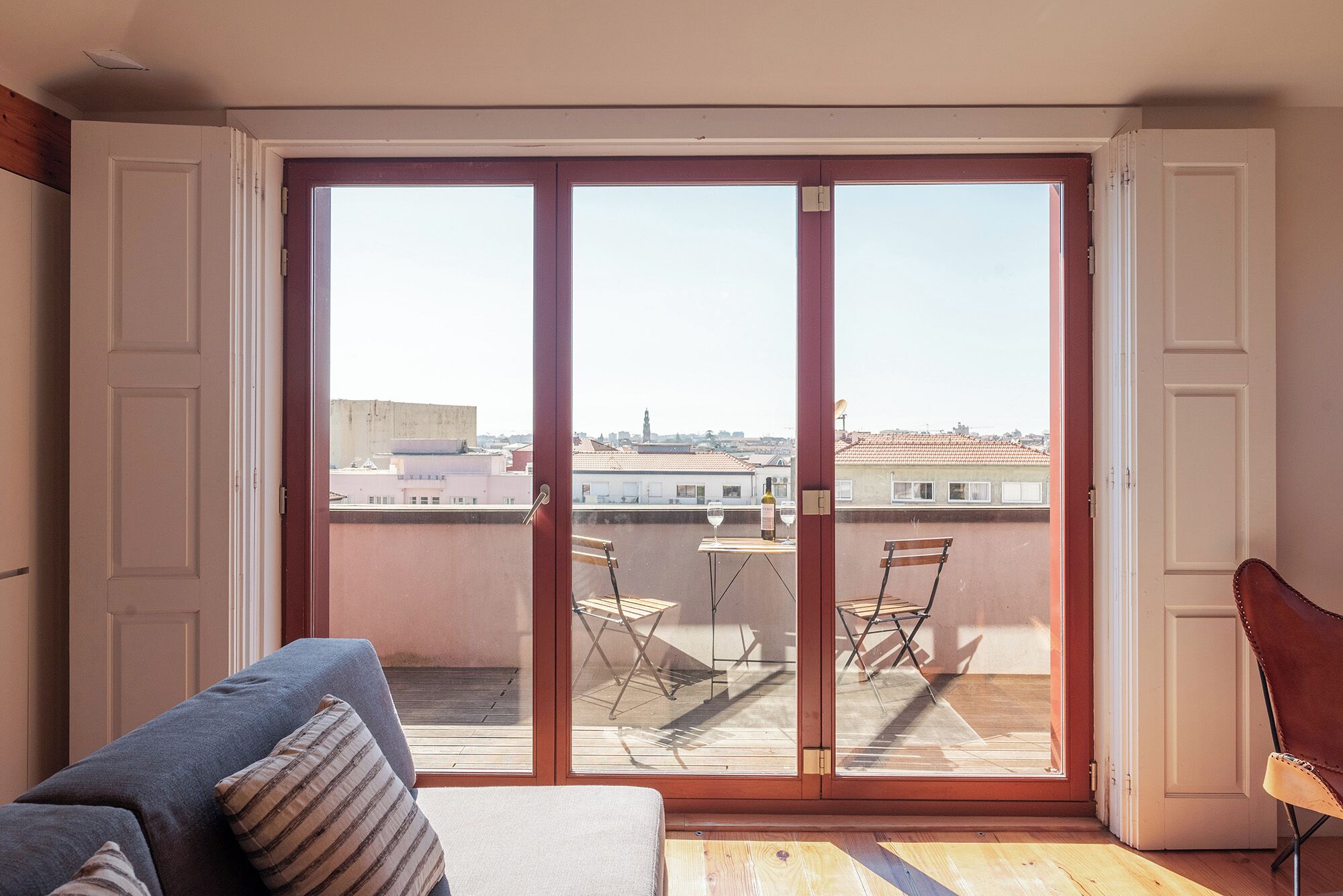 A room with a sliding glass door leading to an outdoor balcony with a table and chairs.
