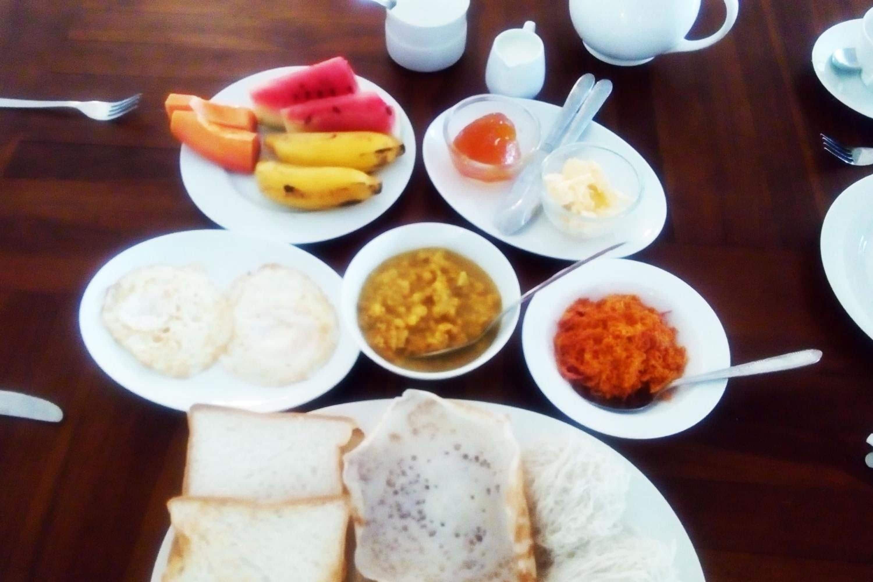 Een tafel met diverse gerechten, zoals brood, fruit en kommen vol eten.