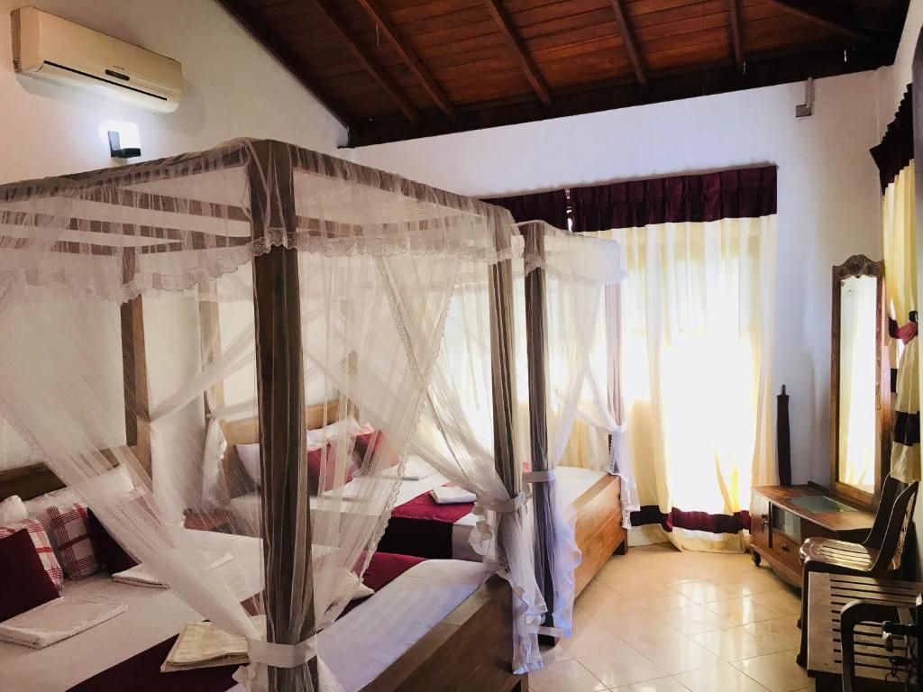 Une chambre avec un lit à baldaquin, une petite table et une chaise.