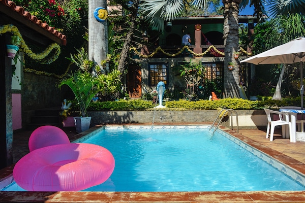 Una piscina al aire libre, sillones reclinables de piscina