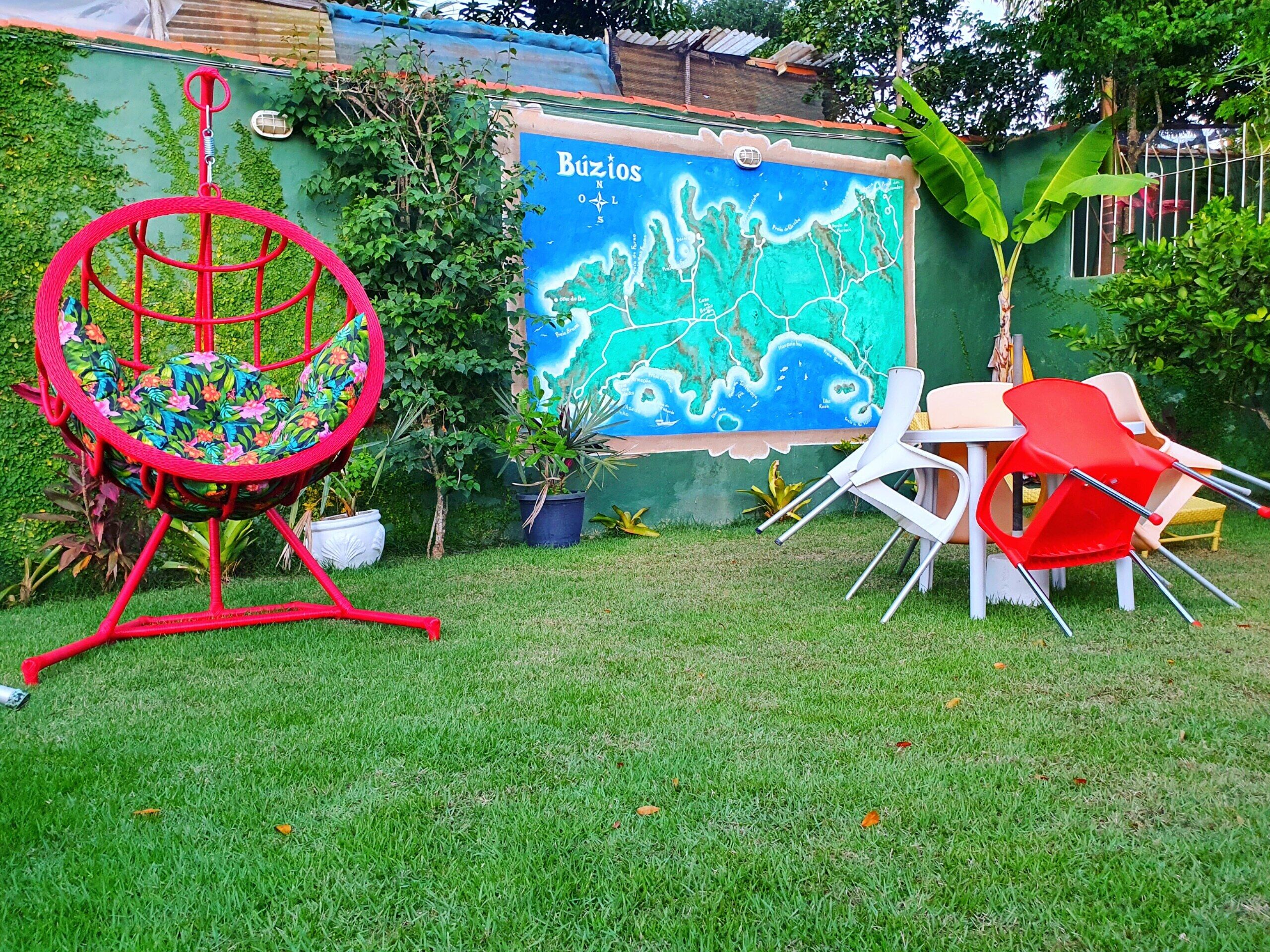 A garden area with a swing chair, a mural, and outdoor seating.
