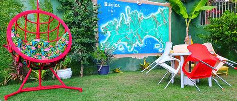 A garden area with a swing chair, a mural, and outdoor seating.