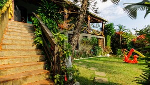 A stone staircase leading to a house with a garden. - Suites Casa do Barão (Búzios)