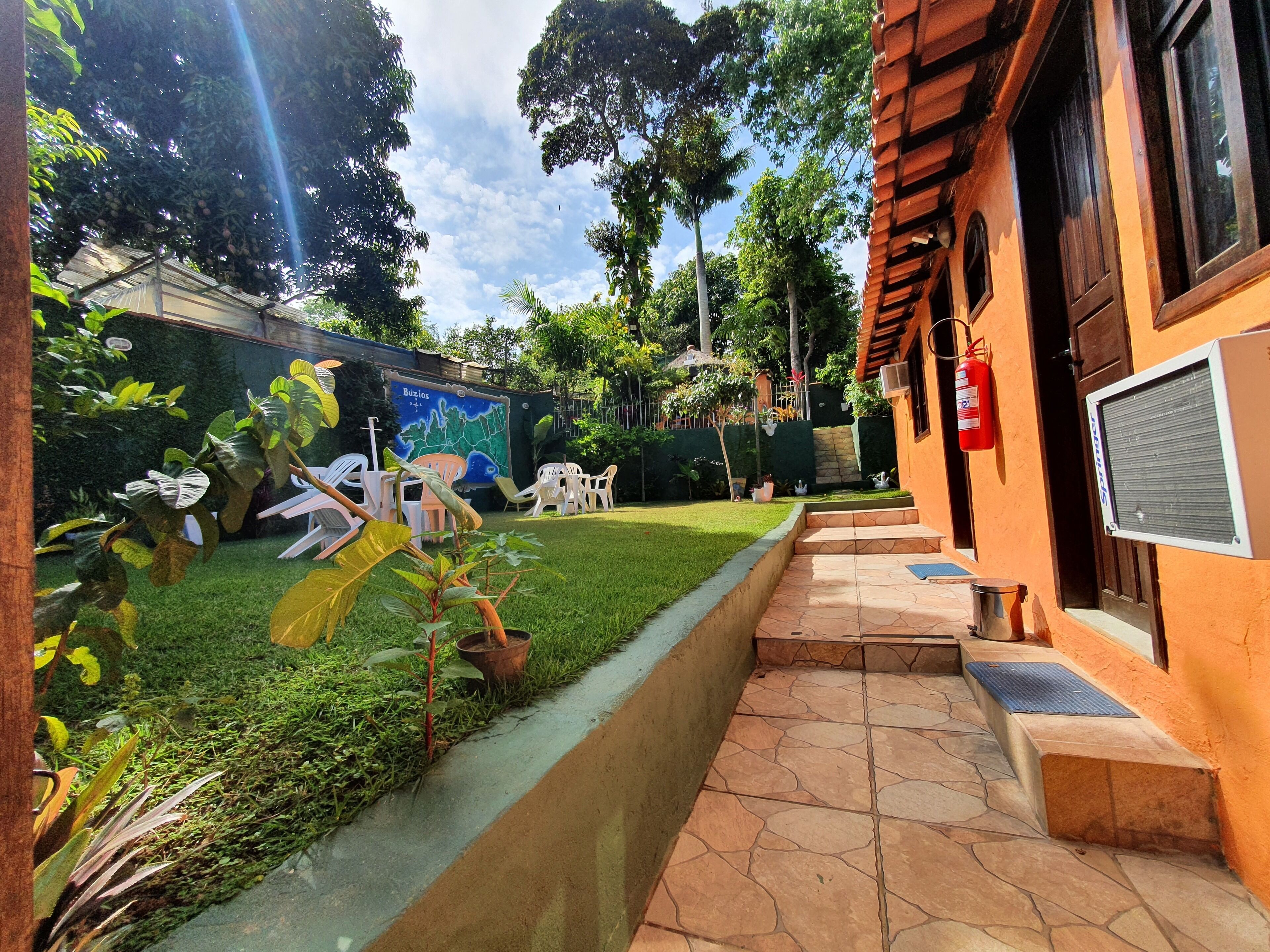 A courtyard with a grassy area, a mural, outdoor furniture, and a building with a fire extinguisher.