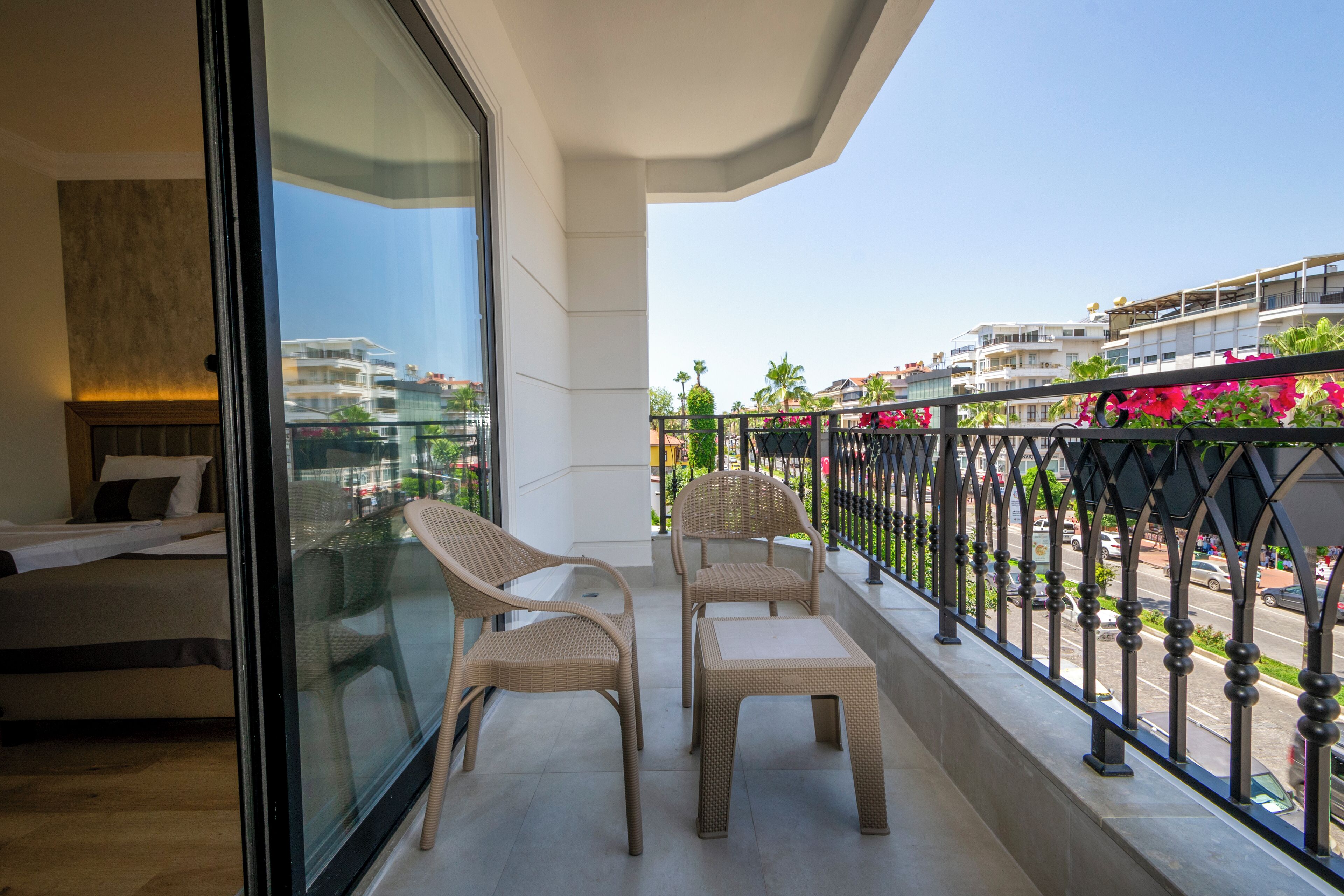Un balcón con mobiliario de mimbre y vista panorámica de la ciudad.