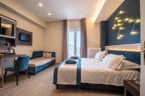 A hotel room with a bed, a desk, a chair, a TV, and a view of the outdoors. - Hotel La Canonica (Lettere)