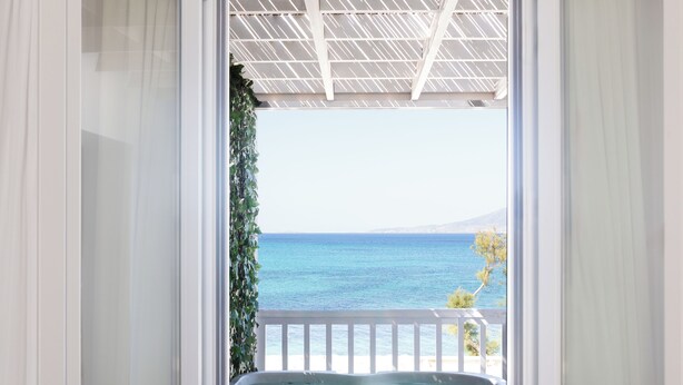 Un balcon avec vue sur la mer et sur une montagne lointaine.