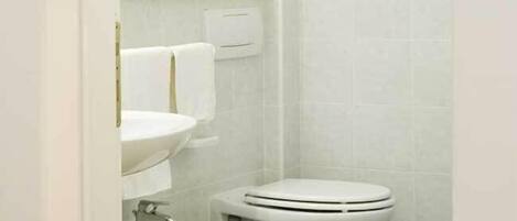 Une salle de bain équipée d’un bidet, de toilettes et d’un lavabo.