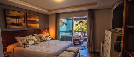 A bedroom with a large bed, a wooden headboard, and a view of a balcony.