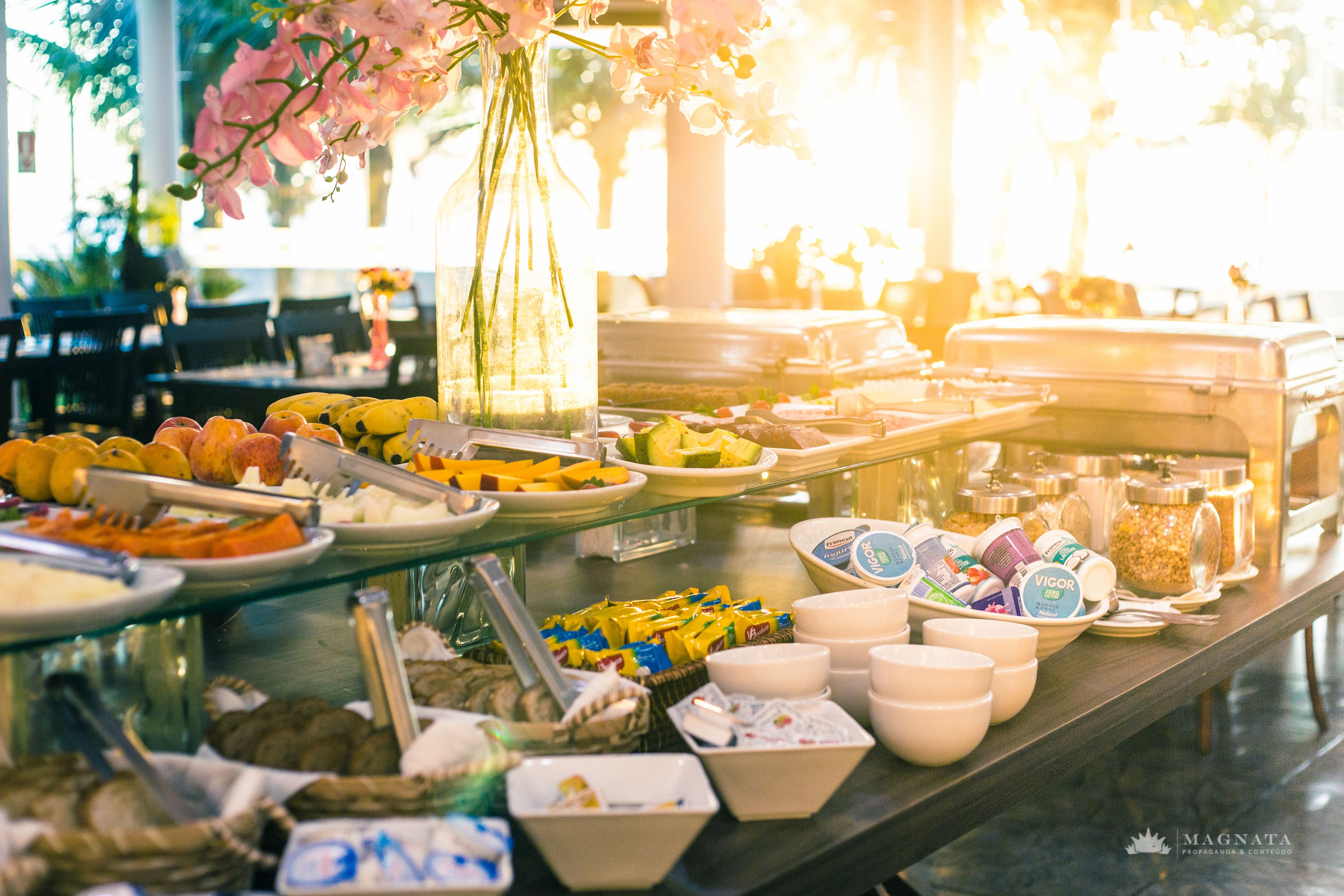 Buffet amb diversos plats i recipients, incloent fruites, aperitius i begudes.