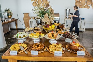 Une table de buffet garnie de différents plats, avec une personne à l’arrière-plan.