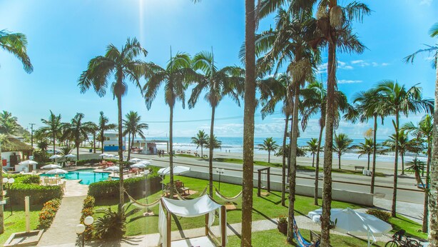 Un resort con piscina, mobiliario exterior y palmeras.