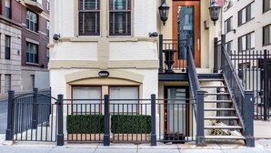 A multi-story building with a central entrance, a small front garden, and a staircase leading to the upper floors. - Fully Furnished Apartment in Washington near Logan Circle (Washington)