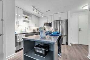 A modern kitchen with white cabinets, stainless steel appliances, and a marble countertop. - Fully Furnished Apartment in Washington near Logan Circle (Washington)