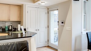 A modern kitchen with a black countertop, white cabinets, and a black leather chair. - Fully Furnished Apartment in Washington near Logan Circle (Washington)