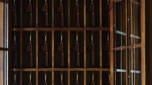 A wooden cabinet with multiple compartments, each holding a hanging key ring. - Greydon House (Nantucket)