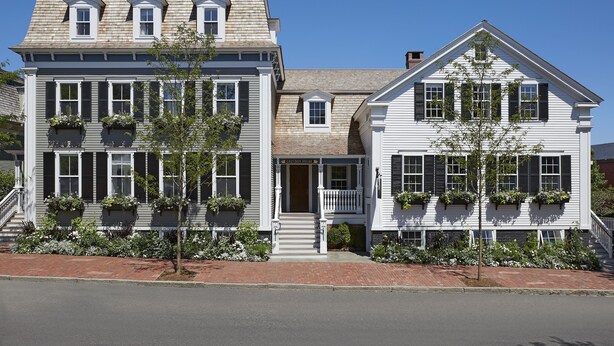 A two-story building with a gabled roof, dormer windows, and a front porch. - Greydon House (Nantucket)