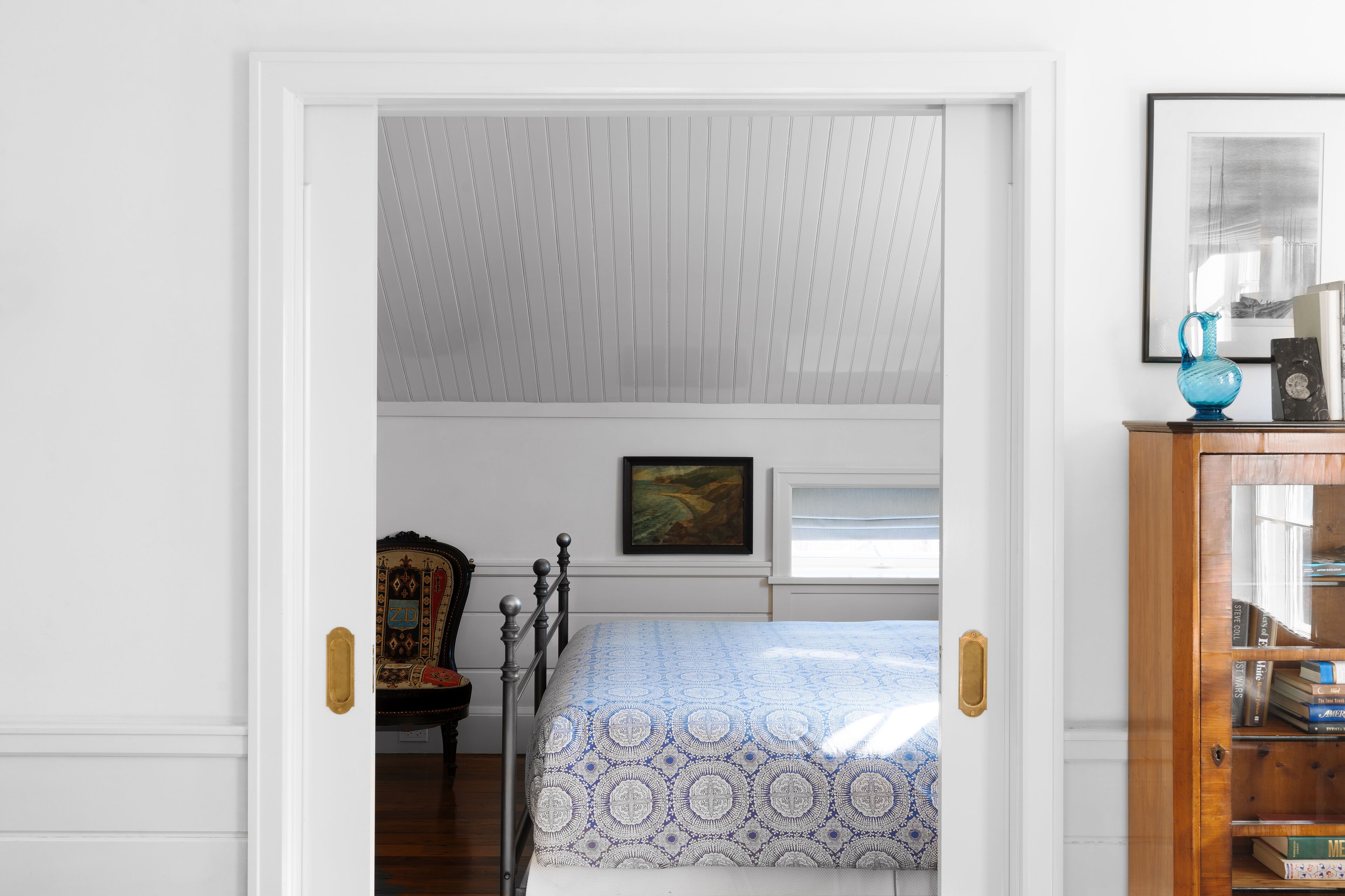 Ein Schlafzimmer mit einem Bett, einem Holzschrank und einem Sessel.