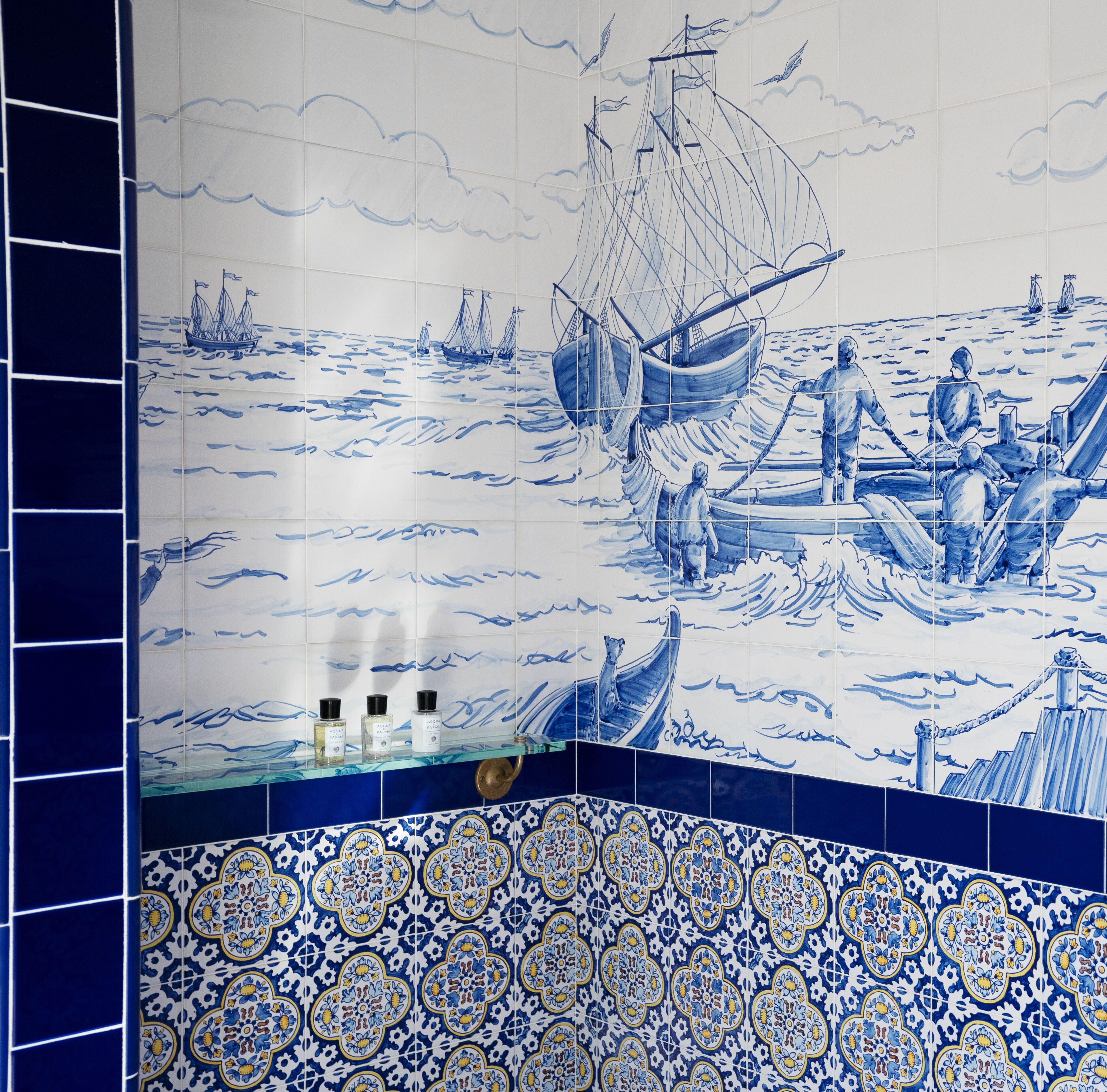 A tiled wall with maritime scenes and decorative patterns.