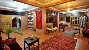 Un salón amplio con un ventanal grande, un sofá, una mesa de centro y una alfombra.