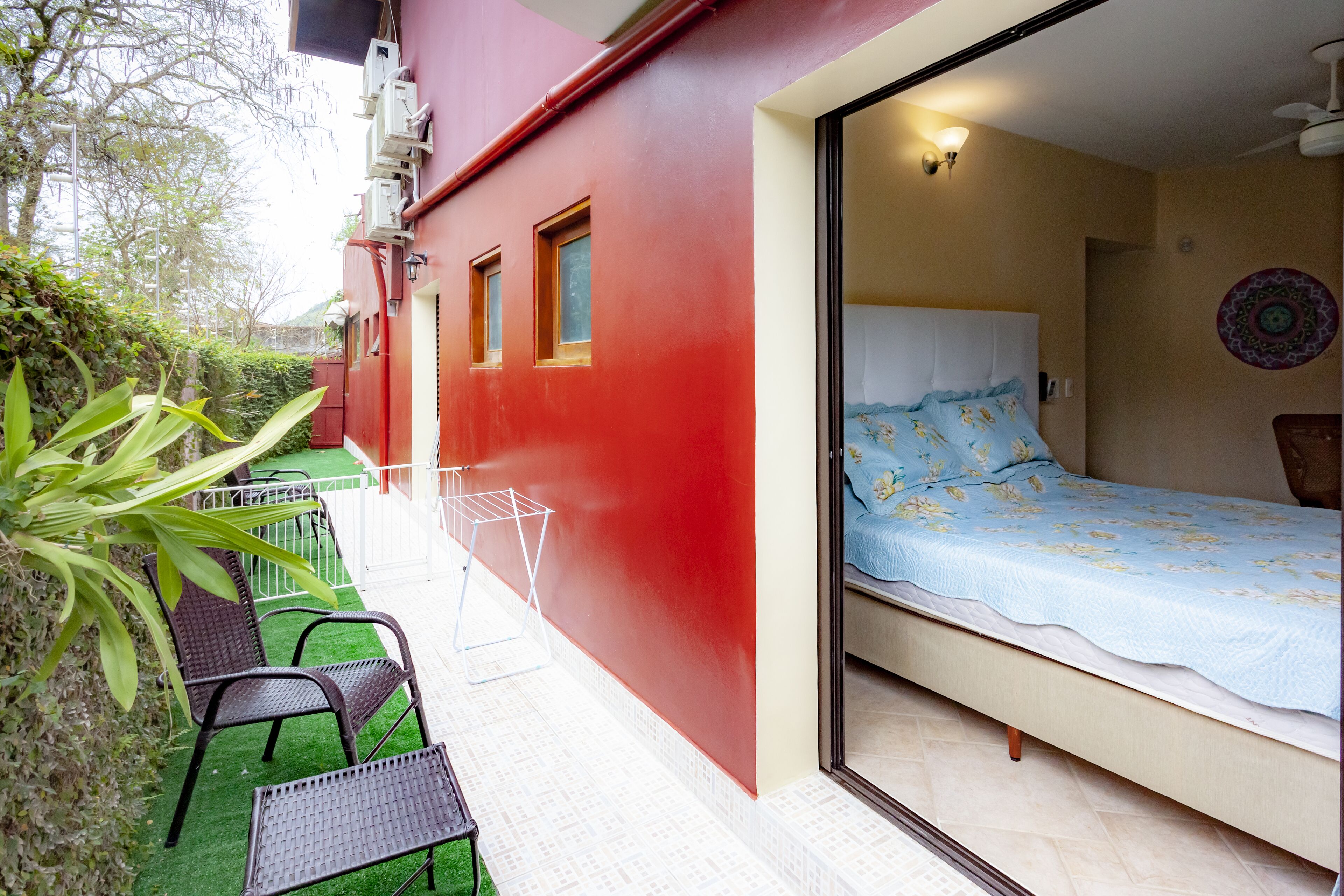 Una habitación con una cama, una mesita y sillas. Hay una ventana y una puerta.