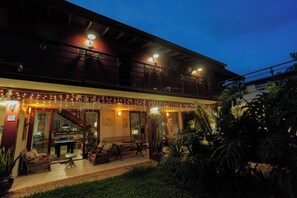 A two-story building with a balcony, string lights, outdoor seating, and potted plants. - Ubatuba Ecologic Pousada (Ubatuba)