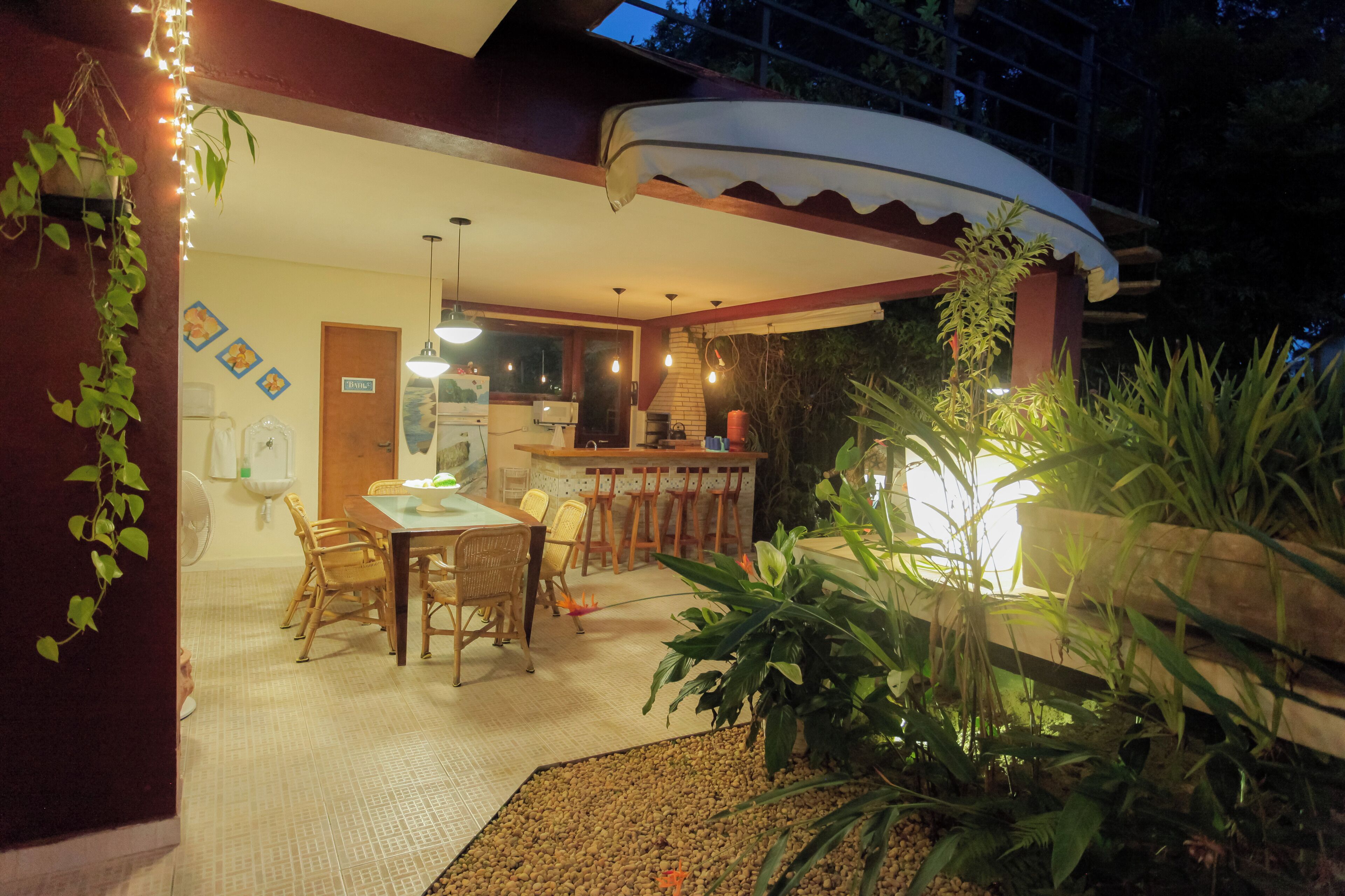 An outdoor dining area with a covered patio, wooden chairs, and a table.