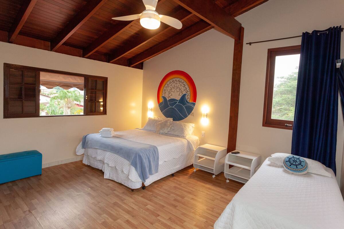 A bedroom with a bed, bedside table, and a window with curtains.