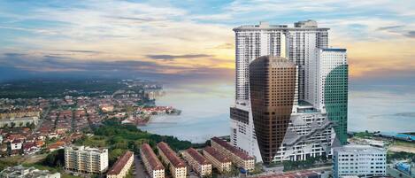 A high-rise hotel with multiple floors, surrounded by a coastal cityscape with a mix of residential and commercial buildings.