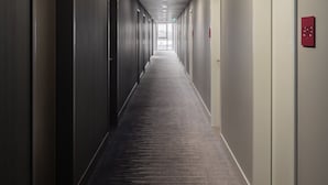 A long, narrow hallway with doors on both sides, leading to individual rooms. - IntercityHotel Duisburg (Duisburg)