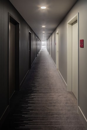 A long, narrow hallway with doors on both sides, leading to individual rooms. - IntercityHotel Duisburg (Duisburg)
