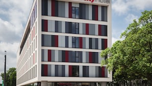 A modern Intercity Hotel building with a striped facade, multiple floors, and a clear sky in the background. - IntercityHotel Duisburg (Duisburg)