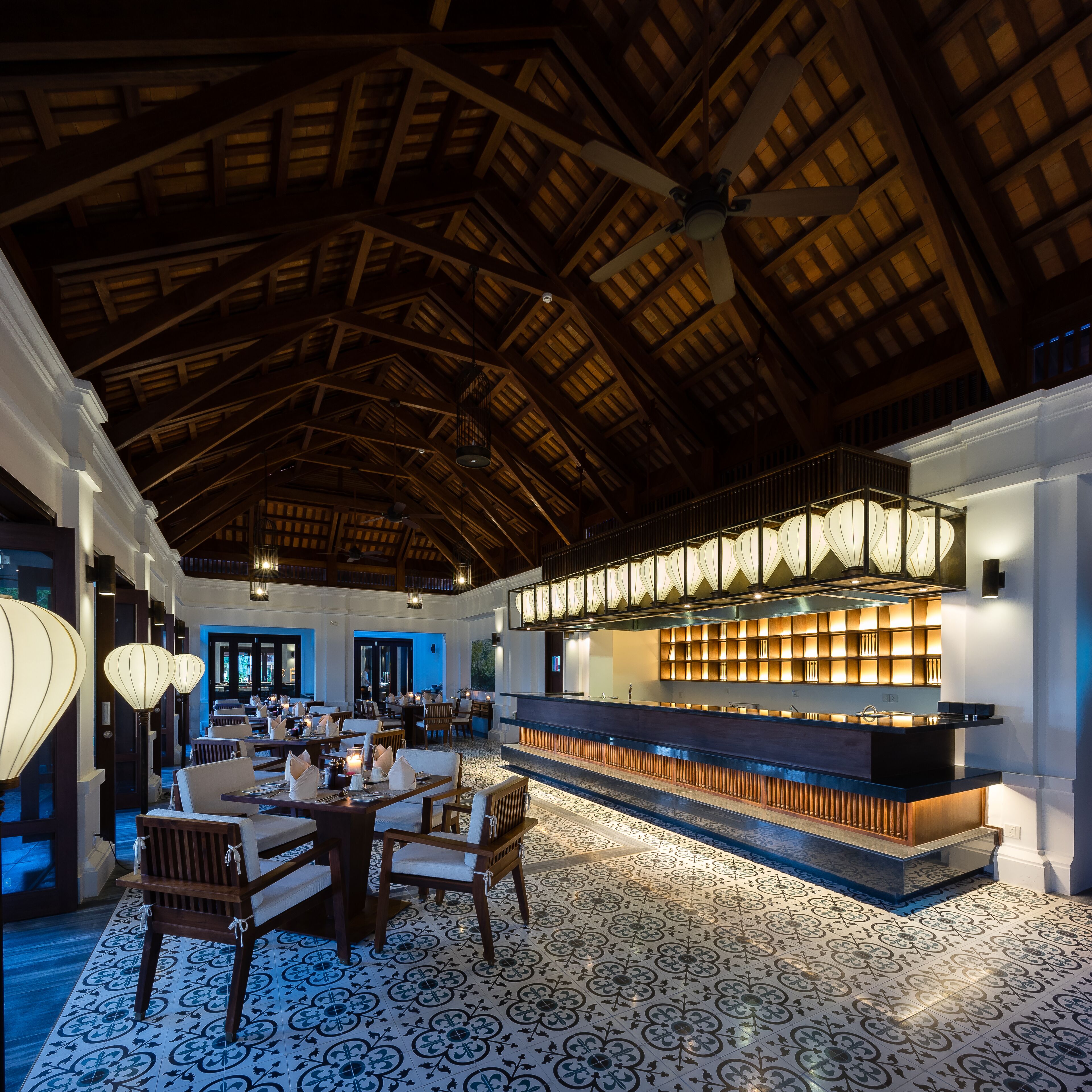 A spacious lobby with a high wooden ceiling, a reception desk, and patterned flooring.