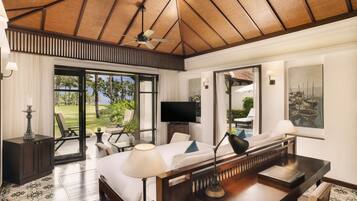 A spacious bedroom with a large bed, a television, and a view of the outdoors.
