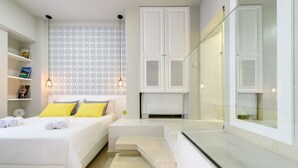 A modern bedroom with a bed, built-in wardrobe, and a glass shower enclosure.