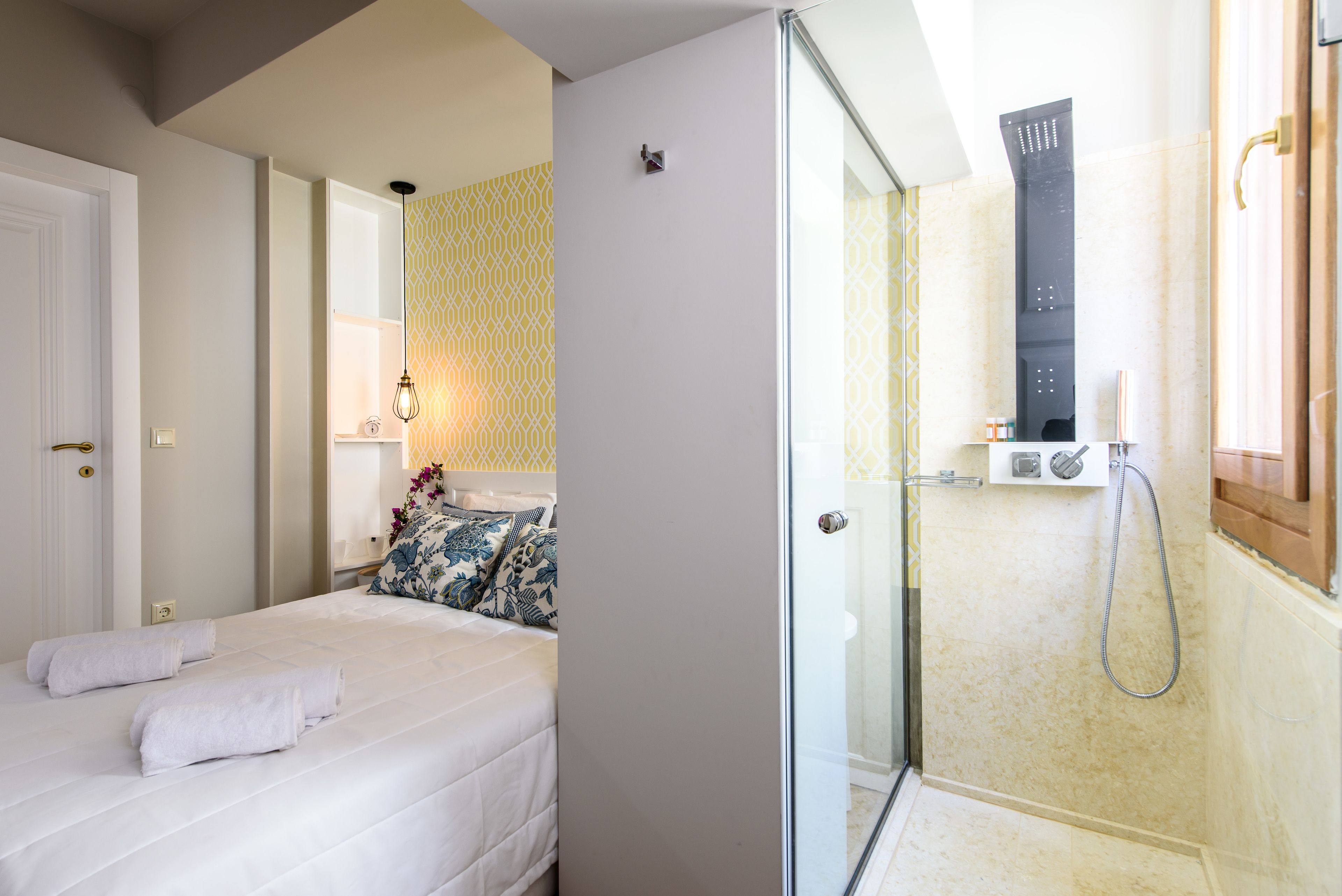 A hotel room with a bed, a shower, and a bathroom.