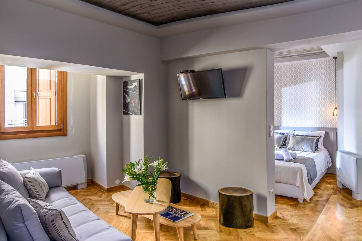 Un salon moderne avec un canapé, une table basse et un téléviseur fixé au mur.