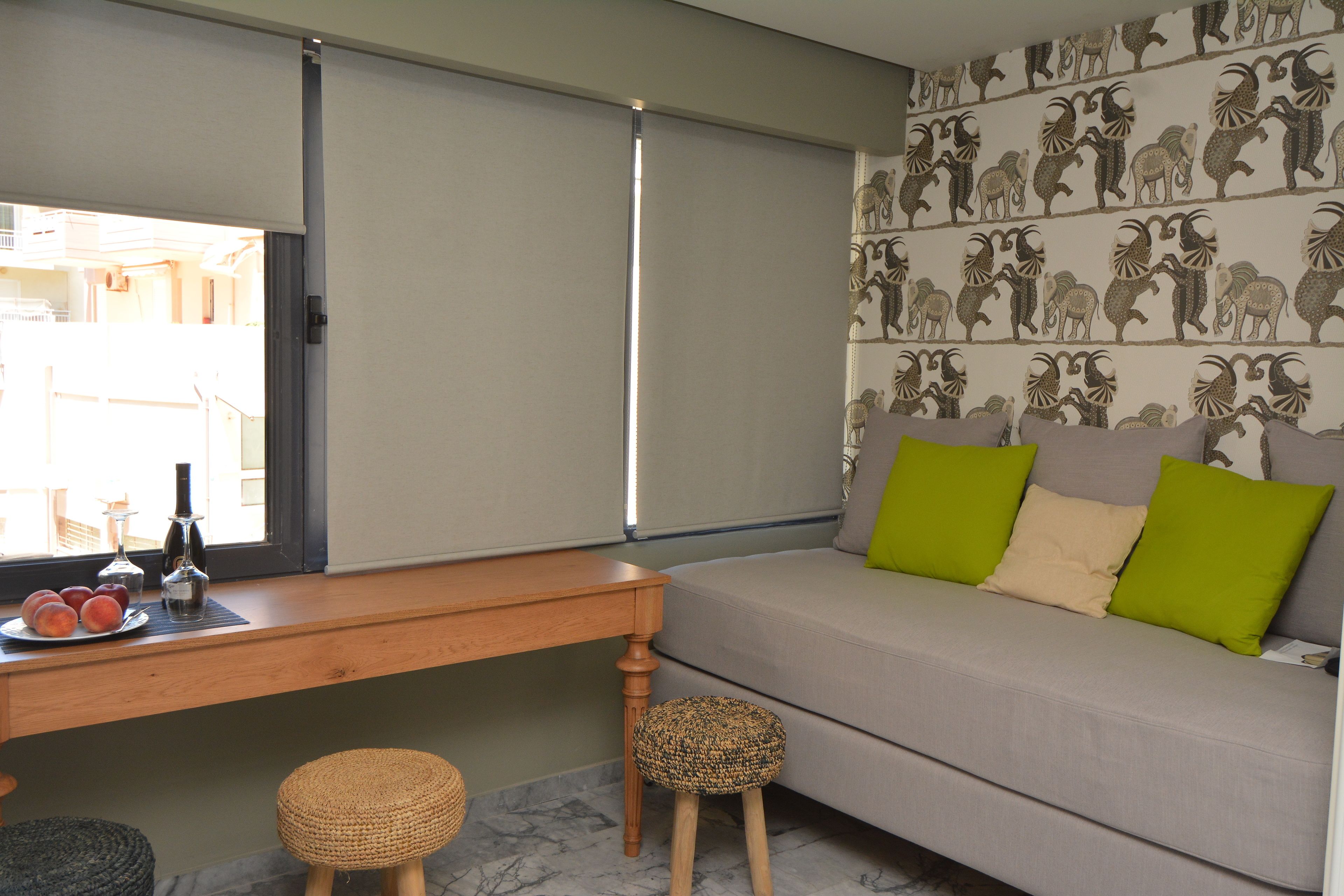 A room with a sofa, a wooden table, and a small stool.