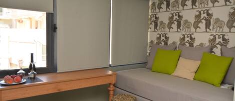 A room with a sofa, a wooden table, and a small stool.
