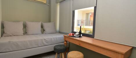 Un dormitorio con cama, un escritorio de madera, un ventanal y vistas al balcón.